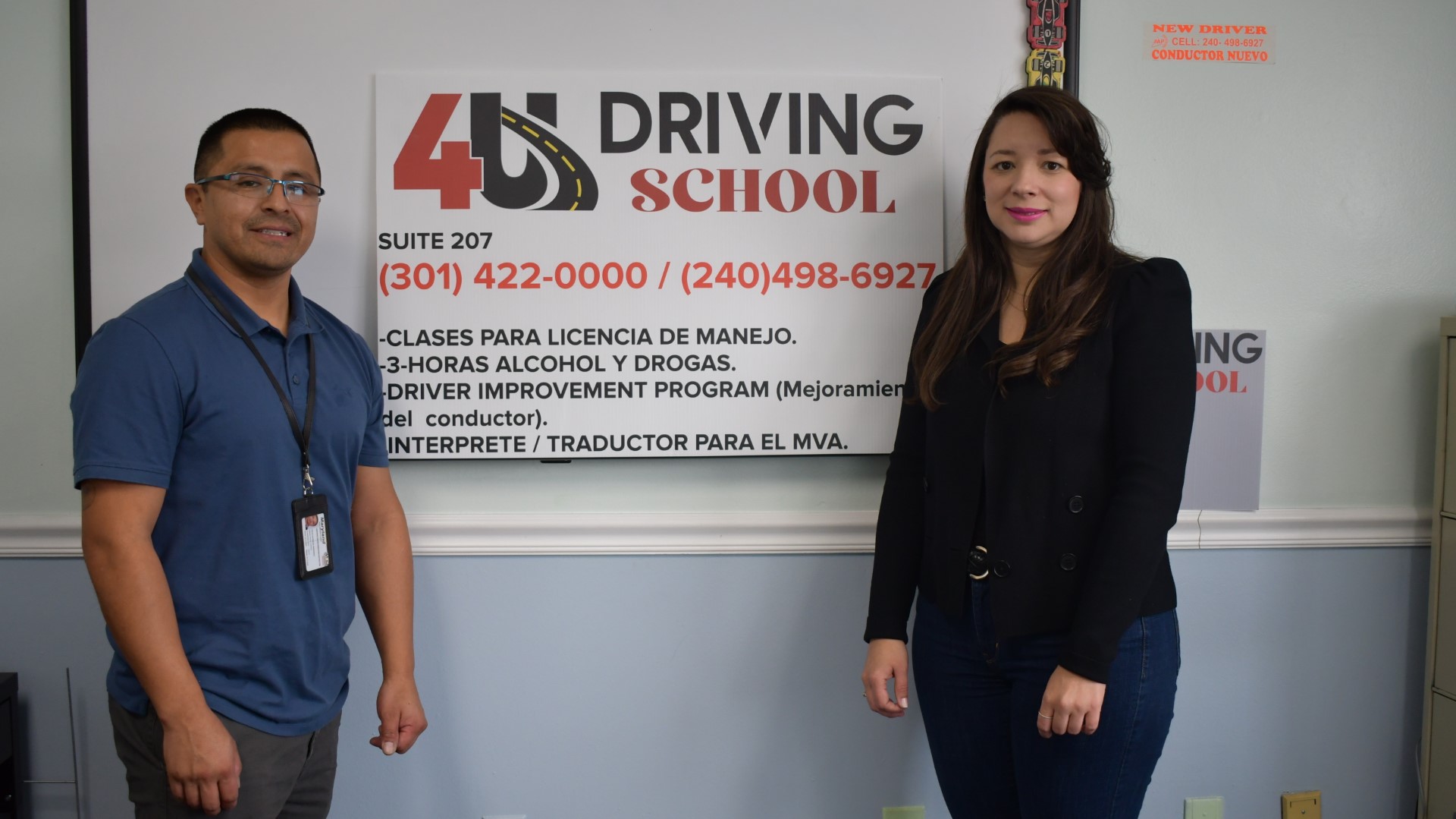 4U Driving School staff standing in front of sign