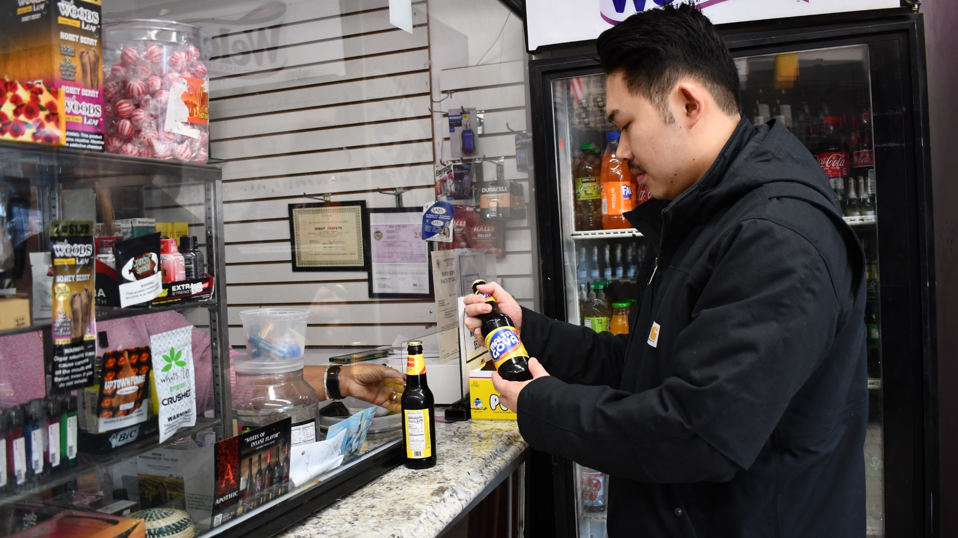 A customer purchasing beverages at the checkout window.